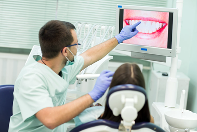 El Dr. Iván Arianes con uno de sus pacientes en consulta explicando el tratamiento de injerto gingival, como uno de los tratamientos regenerativos del envejecimiento dental. 